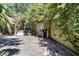 A garage exterior has a door with yellow trim and is surrounded by foliage at 6924 Valrie Ln, Riverview, FL 33569