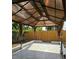 View of shaded gazebo with curtains and a surrounding wooden fence at 7001 60Th N St, Pinellas Park, FL 33781