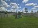 Spacious backyard featuring a playground and green lawn surrounded by a white fence at 7575 Sail Clover Ln, Zephyrhills, FL 33540