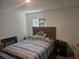 This bedroom features a wooden headboard and a striped blue and grey comforter at 7575 Sail Clover Ln, Zephyrhills, FL 33540