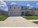 Charming two-story home features a two-car garage, well-maintained lawn, and inviting front porch at 7575 Sail Clover Ln, Zephyrhills, FL 33540