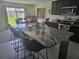 Modern kitchen with granite countertops, stainless steel appliances, and a stylish island with seating at 7575 Sail Clover Ln, Zephyrhills, FL 33540