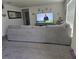 Spacious living room featuring a large sectional sofa, neutral decor, and wall-mounted television at 7575 Sail Clover Ln, Zephyrhills, FL 33540