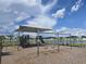 Community playground featuring a covered play structure and swings, perfect for Gathering fun at 7575 Sail Clover Ln, Zephyrhills, FL 33540