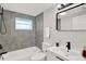 Modern bathroom featuring a tub with gray tiling and sleek black hardware at 7835 Wallaba Ln, New Port Richey, FL 34653