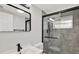 Modern bathroom featuring sleek black fixtures, gray tile, and a glass-enclosed walk-in shower at 7835 Wallaba Ln, New Port Richey, FL 34653