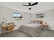 Comfortable bedroom with neutral decor, featuring a ceiling fan and a desk at 7835 Wallaba Ln, New Port Richey, FL 34653