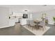 Open-concept dining room features a view to the kitchen with white cabinets and stainless appliances at 7835 Wallaba Ln, New Port Richey, FL 34653