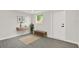 Bright entryway with gray wood-look floors, minimalist decor, and a convenient bench at 7835 Wallaba Ln, New Port Richey, FL 34653