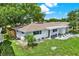Charming single-story home featuring freshly painted white exterior, complementing the well-manicured green lawn and landscape at 7835 Wallaba Ln, New Port Richey, FL 34653