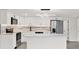 Modern kitchen featuring stainless appliances, marble backsplash, and sleek white cabinets with a center island at 7835 Wallaba Ln, New Port Richey, FL 34653