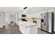 Contemporary kitchen featuring stainless steel appliances, marble backsplash, white cabinets and a center island at 7835 Wallaba Ln, New Port Richey, FL 34653