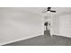 Open living room with gray wood floors, ceiling fan and view into kitchen at 7835 Wallaba Ln, New Port Richey, FL 34653