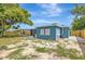 Back view of a charming home featuring a fenced-in yard and screened lanai amid lush greenery at 8033 Norwich Dr, Port Richey, FL 34668