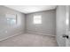 Bright bedroom with carpet floors, neutral walls, and natural light from two windows at 8033 Norwich Dr, Port Richey, FL 34668