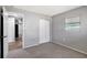 Cozy bedroom featuring neutral walls, carpet flooring, closet, and natural light from a window at 8033 Norwich Dr, Port Richey, FL 34668