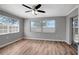 Bright room featuring vinyl floors, neutral walls, ceiling fan, and natural light from three windows at 8033 Norwich Dr, Port Richey, FL 34668