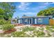 Attractive blue one-story home featuring arched accents, vibrant landscaping, and well-maintained front yard at 8033 Norwich Dr, Port Richey, FL 34668