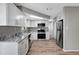 Renovated kitchen with stainless steel appliances, granite counters and wood-look flooring at 8033 Norwich Dr, Port Richey, FL 34668