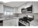 Updated kitchen featuring granite countertops, stainless steel appliances, and lots of natural light at 8033 Norwich Dr, Port Richey, FL 34668