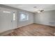 Bright living room featuring wood-look floors, a ceiling fan, and a window for natural light at 8033 Norwich Dr, Port Richey, FL 34668