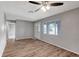 Inviting living room with wood-look flooring, a ceiling fan, and a view of the front door at 8033 Norwich Dr, Port Richey, FL 34668