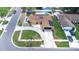 An aerial view of a well-maintained home with solar panels, a spacious driveway, and lush landscaping at 8927 95Th N St, Seminole, FL 33777