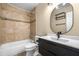 Bathroom featuring a modern vanity, decorative mirror and tiled shower at 8927 95Th N St, Seminole, FL 33777