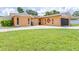Charming single-story home featuring a large driveway and black garage door, with a well-maintained lawn at 8927 95Th N St, Seminole, FL 33777