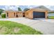 Charming single-story home featuring a large driveway and black garage door, with a well-maintained lawn at 8927 95Th N St, Seminole, FL 33777