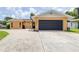Charming single-story home featuring a large driveway and black garage door, with a well-maintained lawn at 8927 95Th N St, Seminole, FL 33777
