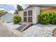A clean, well-maintained shed with a ramp, surrounded by white gravel and lush greenery in a backyard at 8927 95Th N St, Seminole, FL 33777