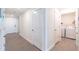 Hallway with tile floors, white walls, and access to the laundry room at 9016 Water Chestnut Dr, Temple Terrace, FL 33637
