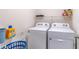 Laundry room with white washer and dryer, storage shelves, and laundry basket at 9016 Water Chestnut Dr, Temple Terrace, FL 33637