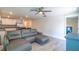 Open-concept living room with a large gray sectional sofa and wood-look flooring at 9016 Water Chestnut Dr, Temple Terrace, FL 33637