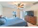 Comfortable main bedroom with a large window and wooden dresser with a TV at 9016 Water Chestnut Dr, Temple Terrace, FL 33637