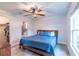 Bright main bedroom with a wooden bed frame, ceiling fan, and ensuite bathroom at 9016 Water Chestnut Dr, Temple Terrace, FL 33637