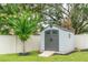 Backyard storage shed with gray double doors and surrounding tree at 9016 Water Chestnut Dr, Temple Terrace, FL 33637
