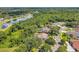 An aerial shot shows the property situated near a pond, surrounded by lush greenery and mature trees at 9202 Brindlewood Dr, Odessa, FL 33556