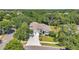 Gorgeous aerial view of a well-maintained home with lush landscaping and a three car garage at 9202 Brindlewood Dr, Odessa, FL 33556