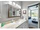 Bathroom with large mirror, marbled vanity, and natural light with view to outdoor space at 9202 Brindlewood Dr, Odessa, FL 33556