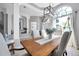Bright dining room boasts a grand window, modern chandelier, and neutral decor for elegant gatherings at 9202 Brindlewood Dr, Odessa, FL 33556