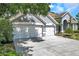 Spacious three-car garage with white doors and gray exterior, offering ample parking and storage at 9202 Brindlewood Dr, Odessa, FL 33556