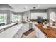 Bright kitchen with white cabinets, quartz countertops, stainless steel appliances, and breakfast bar seating at 9202 Brindlewood Dr, Odessa, FL 33556