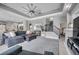 Open-concept living area with staircase, comfortable gray furniture, and view to the kitchen and bedrooms at 9202 Brindlewood Dr, Odessa, FL 33556