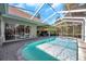 Inviting screened-in pool area with brick pavers, lush landscaping, and partial view of the backyard at 9202 Brindlewood Dr, Odessa, FL 33556
