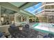 Screened-in lanai features a dining table with seating and views of the pool and backyard at 9202 Brindlewood Dr, Odessa, FL 33556
