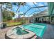 Inviting in-ground pool and spa are surrounded by a screened-in enclosure and paver patio at 9202 Brindlewood Dr, Odessa, FL 33556