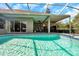 Bright, screened-in pool area with built-in spa, brick pavers, and outdoor seating at 9202 Brindlewood Dr, Odessa, FL 33556