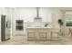 Modern kitchen with stainless steel appliances, white cabinets, and an island with seating at 9497 Minnow Ray Dr, Land O Lakes, FL 34638